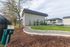 Charming apartment exterior with well-maintained pathways, lush green lawn, and convenient parking area.