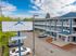 Contemporary blue and gray Theodore Apartments exterior with spacious balconies, set against a picturesque sky.
