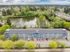 Charming apartment complex surrounded by lush greenery and a serene lake, offering a tranquil urban escape with convenient parking and scenic views.