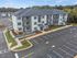 Modern multi-level apartment building with spacious balconies and ample parking. Surrounded by lush greenery, offering a serene and inviting living environment.