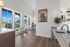 Bright and inviting kitchen dining area with large windows, hardwood floors, and modern decor, perfect for relaxing or entertaining.