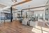 Expansive contemporary living area with elegant wood beams, chic furniture, and abundant natural light.