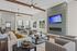 Elegant open-concept living room with contemporary decor, featuring plush seating, sleek fireplace, and abundant natural light from large windows.