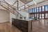 Luxurious open-concept living space with a grand staircase, modern kitchen island, and floor-to-ceiling windows offering stunning views.