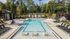 Luxurious outdoor pool with elegant lounge chairs and private cabanas surrounded by lush greenery.