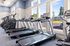 Bright and modern fitness center with state-of-the-art treadmills and exercise equipment, overlooking a scenic outdoor view through large windows.
