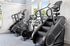 Bright and modern gym with state-of-the-art exercise bikes and stair climbers under natural light.