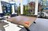 Modern outdoor recreational area featuring a stylish ping pong table with seating, vibrant greenery, and poolside views.