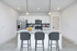 Modern kitchen with sleek white cabinetry, stainless steel appliances, and a stylish island with pendant lighting and bar seating.