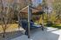 Elegant outdoor space featuring a modern gazebo with comfortable seating, surrounded by lush greenery and a hammock for relaxation.