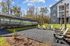 Charming outdoor seating area with Adirondack chairs and a vibrant mural, providing a serene community retreat by modern apartments.
