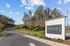 Inviting entrance to Novo Sweetwater, featuring a scenic roadway lined with lush trees and vibrant landscaping.