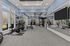Modern fitness center with state-of-the-art equipment, featuring exercise bikes, weights, and expansive mirrors in a bright and spacious setting.