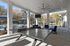 Inviting outdoor lounge area featuring a ping pong table and comfortable seating, overlooking a sparkling pool with umbrellas and surrounded by lush trees.
