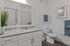 Elegant bathroom with modern granite countertop, stylish white cabinetry, and chic blue accents for a sophisticated touch.