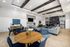 Chic and inviting common area boasting modern decor with comfortable seating, stylish wooden tables, and an elegant textured wall design.