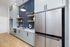 Modern kitchen with sleek cabinetry, elegant blue chevron backsplash, and stainless steel refrigerator.