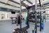 Modern fitness center with state-of-the-art equipment, featuring weight racks, exercise bikes, and a sleek design.