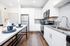 Modern kitchen with sleek white cabinets, stainless steel appliances, and elegant granite countertops.