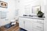Elegant bathroom with sleek granite countertop, modern fixtures, and stylish decor including blue accents and a decorative plant.