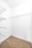 Spacious walk-in closet with elegant shelving and plush carpet, perfect for stylish storage solutions.