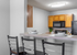 Contemporary kitchen with sleek countertops, modern appliances, and stylish bar seating for a perfect culinary experience.