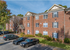 Charming brick apartment building with classic architecture, surrounded by lush greenery, featuring ample parking and inviting curb appeal.