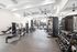 Spacious modern gym with high-end fitness equipment, bright natural lighting, and sleek design, perfect for wellness enthusiasts.