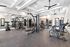 Modern fitness center with cutting-edge gym equipment, mirrored walls, and ample natural lighting.