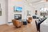 Contemporary open-concept living space featuring elegant leather chairs, a modern fireplace, and a view of the pool through expansive windows.