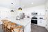 Modern kitchen with sleek white cabinetry, stainless steel appliances, and a stylish granite island with pendant lighting and chic seating.