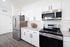 Modern kitchen with sleek stainless steel appliances, pristine white cabinetry, and elegant granite countertops.