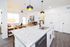 Modern kitchen with granite countertops and stylish pendant lighting, leading to a bright and inviting open living area.
