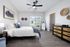 Charming bedroom with natural light, elegant artwork, cozy bedding, modern ceiling fan, and stylish decor touches.