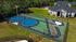 Aerial view of a vibrant entertainment area featuring a unique, colorful painted track and playground, surrounded by lush greenery and modern apartment buildings.