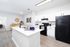 Contemporary kitchen with sleek white cabinets, modern appliances, and inviting open layout, perfect for entertaining.
