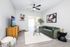 Bright and modern living room with a cozy green sofa, stylish coffee table, and wall-mounted television. Features contemporary decor and a seamless flow into the dining area, complemented by natural light.