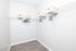 Spacious walk-in closet with sleek wire shelving, stylish storage bins, and elegant wooden flooring.