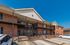 Charming two-story apartment building with red brick exterior, elegant black railings, and convenient private parking.