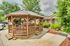 Charming wooden gazebo in a lush garden setting, perfect for relaxing and enjoying the outdoors at this inviting property.