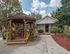 Charming outdoor gazebo with lush greenery in a serene courtyard setting, perfect for relaxing and socializing.