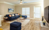 Inviting living room with a chic navy sectional sofa, modern coffee tables, and warm wooden flooring, perfect for relaxation and entertaining.