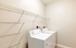 Bright laundry room with modern washer and dryer, featuring spacious shelving for optimal organization.