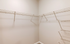 Spacious walk-in closet with sleek wire shelving and neutral walls, perfect for organized storage.