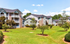 Charming apartment complex with modern architecture, featuring lush green lawns and expansive outdoor spaces.