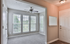 Inviting entryway with plush carpet, large windows, and a ceiling fan, offering ample natural light and a cozy atmosphere.