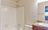 Elegant bathroom with a sleek tiled bathtub, modern fixtures, and granite countertop sink.