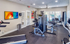 Modern fitness center featuring state-of-the-art gym equipment with vibrant artwork and abundant natural light.