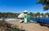 Charming lakeside playground with a vibrant slide and climbing structure, nestled beside a serene swimming pool and picturesque lake view.