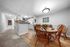 Inviting dining area with warm wooden furniture, adjacent to a modern kitchen, creating a cozy and welcoming atmosphere.